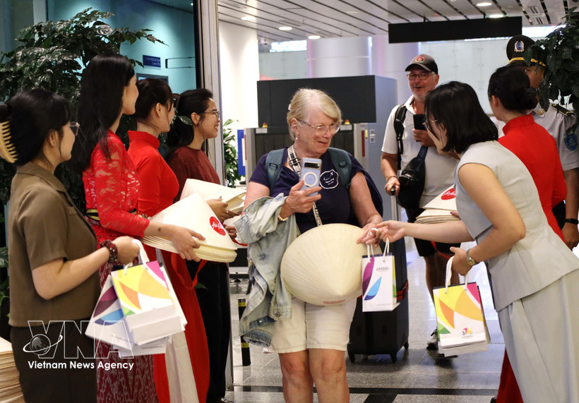 Offre des cadeaux aux passagers venus de Manille (Philippines) et de Bali (Indonésie). Photo: VNA
