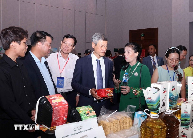 Nguyen Minh Vu, ambassadeur du Vietnam au Cambodge, et des entreprises cambodgiennes visitent le stand vietnamien. Photo : VNA