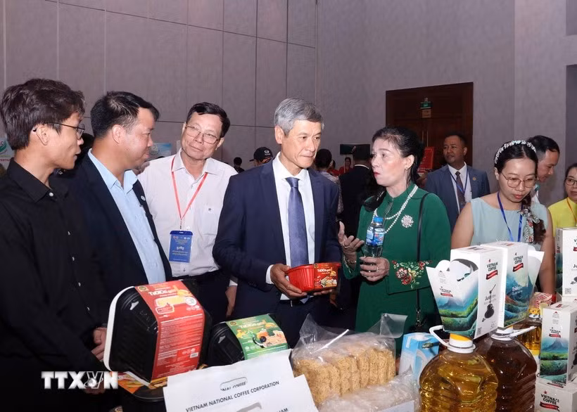 Nguyen Minh Vu, ambassadeur du Vietnam au Cambodge, et des entreprises cambodgiennes visitent le stand vietnamien. Photo : VNA