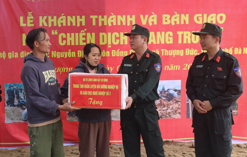 Le général de division Pham Hong Phuc (à droite), du commandement de la police mobile, félicite la famille de Nguyen Dinh, commune de Thuong Duc, pour leur nouvelle maison. Photo : VNA