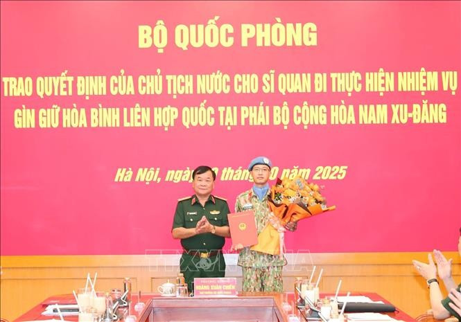 Le général de corps d'armée Hoàng Xuân Chiên, vice-ministre de la Défense remet la décision du président de la République au commandant Lê Vinh Hoàng, nommé pour participer à la mission de maintien de la paix des Nations Unies au Soudan du Sud. Photo: VNA