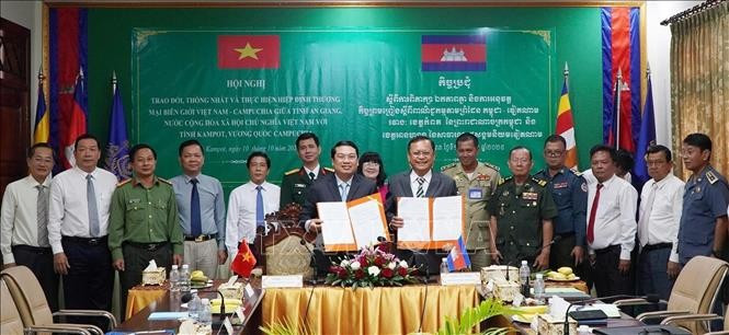 Le vice-président du Comité populaire provincial, Le Trung Ho (à gauche) et Khiev Rithiphorn, vice-gouverneur de la province de Kampot, signent un accord sur la mise en œuvre de l'accord commercial frontalier Vietnam-Cambodge. Photo : VNA