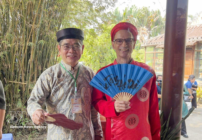 Des diplomates étrangers vêtus de l’ao dai traditionnel vietnamien lors de l'événement. Photo: VNA