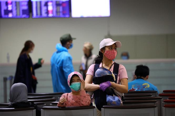 Une famille vietnamienne arrivant d'Europe attend à l'aérogare T2. Photo: VNA