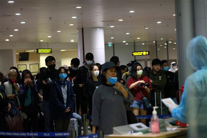 Des passagers en provenance des zones épidémiques font la queue pour entrer dans les lieux isolés à l'aéroport. Photo: VNA