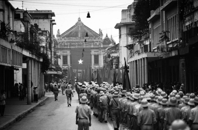 Des soldats marchent dans la rue Trang Tiên en direction de l'Opéra de Hanoï lors de la cérémonie de célébration de la réunification à Hanoï en mai 1985. Photo: Philip Jones Griffiths.