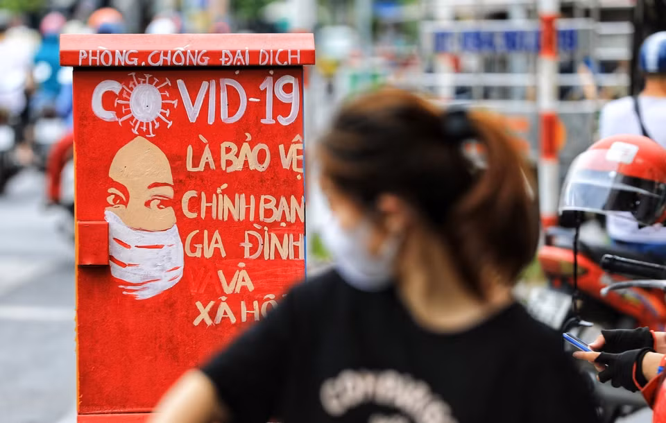 Les affriches sur les coffrets électriques sensibilisent les habitants locaux aux efforts communs dans la lutte contre le coronavirus. Photo: VNA