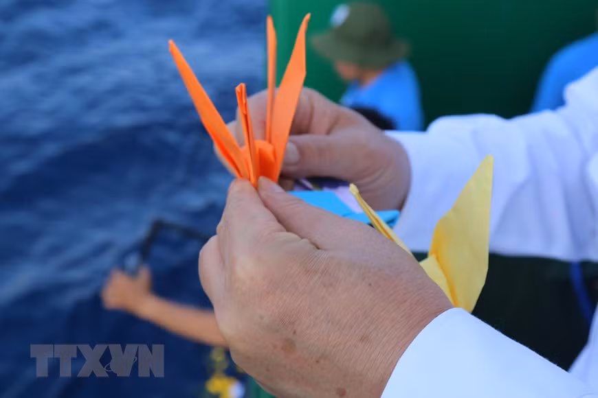 Des grues en papier et fleurs lâchés en mer en mémoire des soldats tombés pour Truong Sa. Photo: VNA