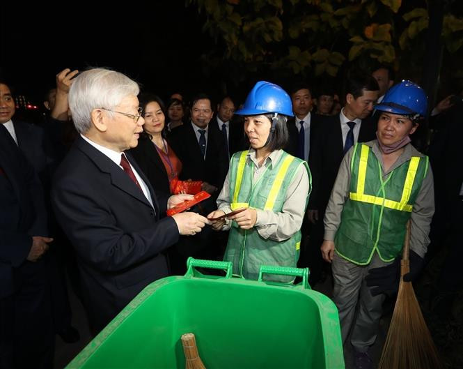 Le secrétaire général du Parti et président vietnamien, nguyên Phu Trongg a rendu visite et offert des cadeaux aux employées travaillant la nuit de réveillon, le 4 février 2019. Photo: VNA