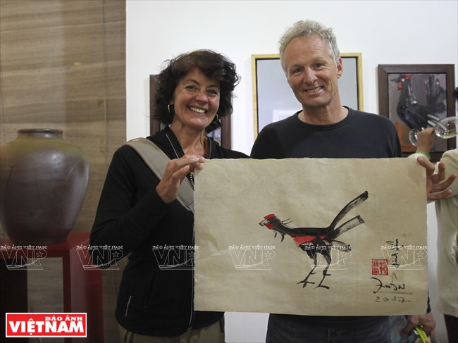 Deux visiteurs étrangers ravis d’un tableau créé sur place.