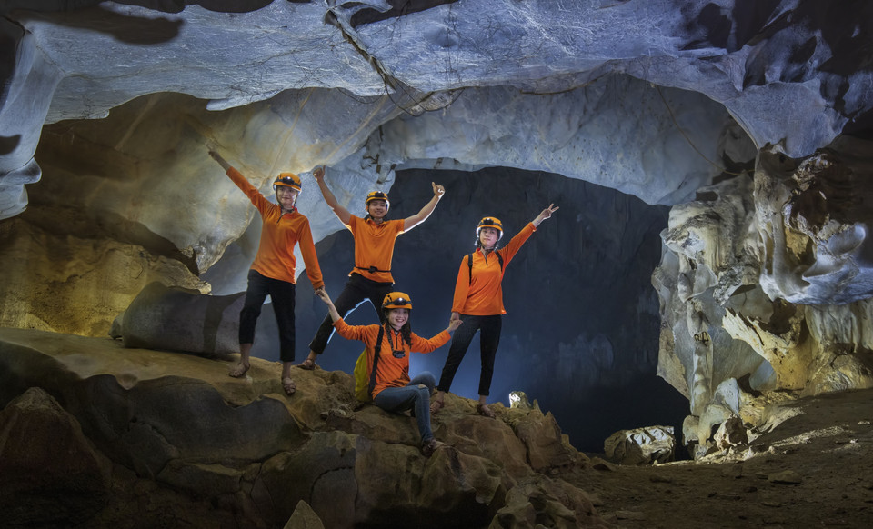 Un groupe de jeunes ravis après un circuit de 4 heures à la découverte de la grotte de Kieu. En sortant de la grotte, ils campent dans la vallée de l'Amour et dégustent des plats locaux.