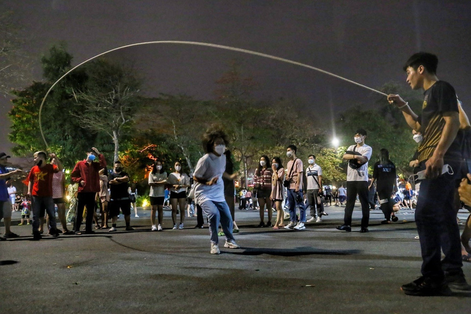 Des jeunes jouent à des jeux folkloriques dans l'espace piétonnier autour du lac Hoan Kiem. 