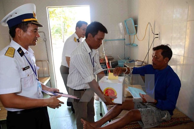 Un pêcheur de la province de Binh Thuan dans l'infirmerie de l'île de Song Tu Tay réalise son droit et devoir de vote.