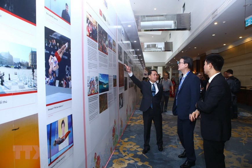 Le directeur général de VNA, Nguyen Duc Loi, et les délégués ont regardé les photos présentant les agences de presse membres de l'OANA. Photo: VNA