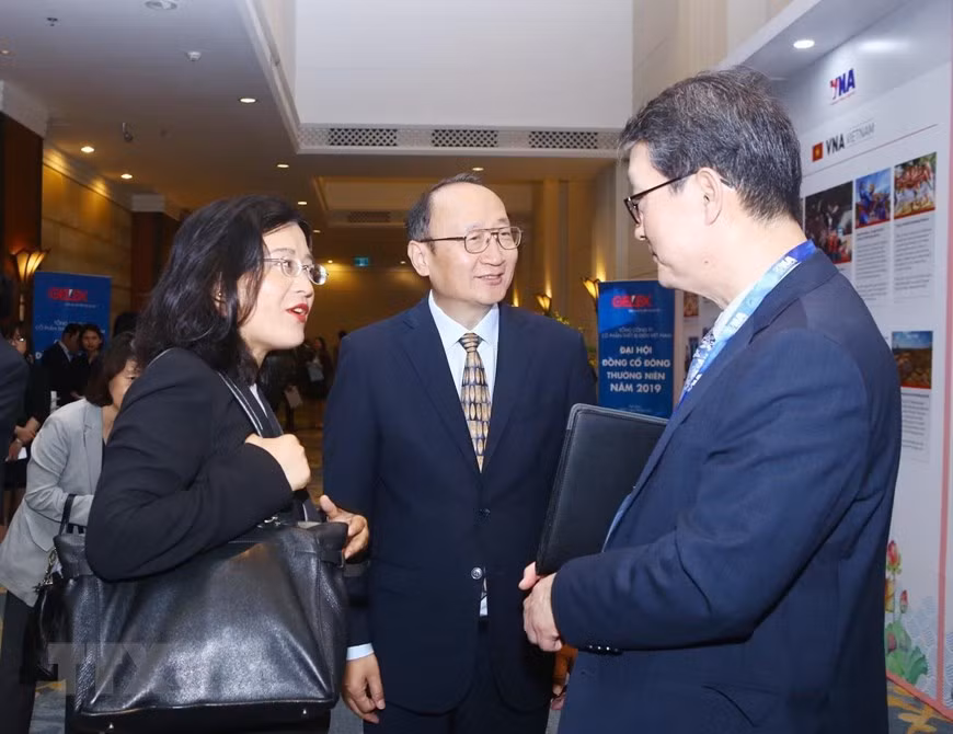 Des délégués échangent leurs points de vue en marge de cette réunion. Photo: VNA 