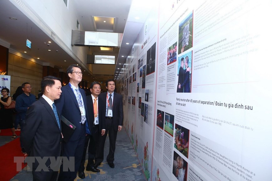 Le directeur général de la VNA, Nguyên Duc Loi, et les délégués regardent des informations sur les agences de presse membres de l'OANA. Photo: VNA