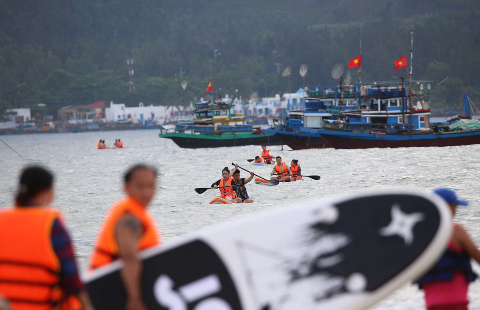  Les touristes font l'expérience du stand up paddle sur la plage de Man Thai. Photo: VNA 