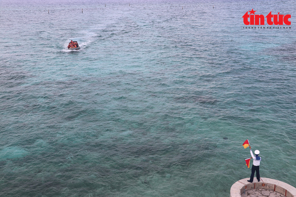 Un soldat guide un bateau dans le chenal de l'île de Da Tay B.
