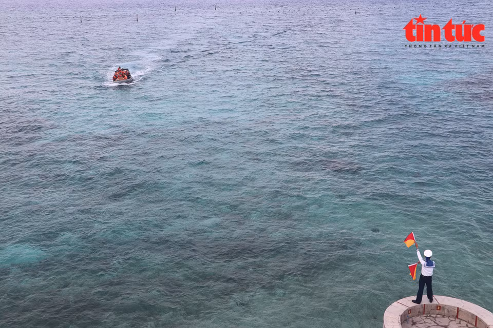 Un soldat guide un bateau dans le chenal de l'île de Da Tay B.