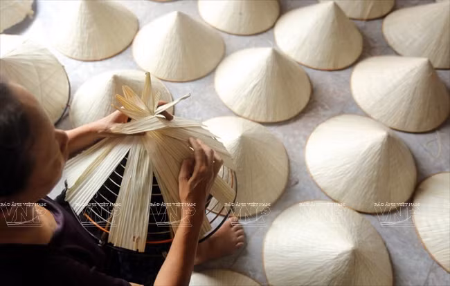 Nguyên Thi Sau, de la commune de Liêu Châu, Phu Châu, assemble un chapeau conique.