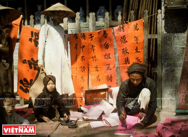 Lettrés écrivant des sentences parallèles pendant le Têt dans une rue de Hanoi il y a plus d'un siècle. 