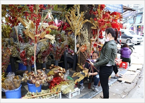 Un vendeur prépare les arbres dorés et argentés.