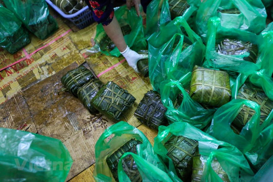 Le "banh chung" est coupé en tranche ou en morceaux et déposé sur une assiette. Il est souvent consommé avec des oignons blancs au vinaigre, car sa saveur aigre et légèrement poivrée facilite la digestion. Grâce à son goût délicieux, sa légende historique et sa signification philosophique, le "banh chung" est devenu un symbole non seulement de la gastronomie du Vietnam mais encore du rassemblement familial et de la reconnaissance envers les ancêtres. La confection du "banh chung" pendant le Têt reste ainsi une belle coutume pour garder l’âme du Têt vietnamien et enrichir la tradition culinaire en particulier et la culture vietnamienne en général. Photo: Vietnam+