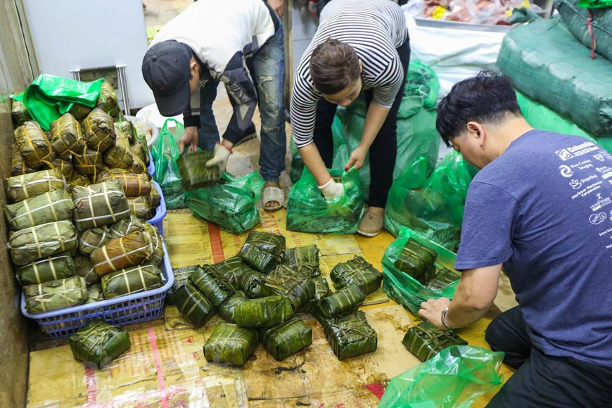 Le magasin, qui a démarré ses activités il y a environ 200 ans, est réputé pour ses banh chung et autres délices du Têt, en utilisant des recettes et des méthodes de cuisson traditionnelles. Des banh chung sont emballés séparément dans des sacs en plastique selon les exigences du client. Les banh chung du magasin Quoc Huong sont célèbres pour leur peau fine, leur saveur de riz, leurs garnitures savoureuses et leur goût unique. Le banh chung a une nutrition avec une saveur savoureuse originale et peut se conserver longtemps. Manger un banh chung avec des cornichons de légumes vous apportera un goût inoubliable. Photo: Vietnam+