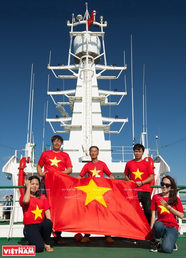 Les Viet kieu en t-shirt à l’effigie du drapeau national posent pour une photo souvenir. 