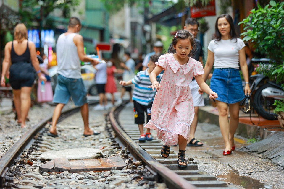 Les enfants rentrent de l’école en traversant le passage à niveau. Issus de la campagne, la plupart des habitants du quartier conservent le mode de vie communautaire comme dans leurs villages d’origine. Les gens de la rue du train ont appris à s’adapter au danger en permanence : ils ont acquis une aptitude hors pair pour faire face à l’insécurité du lieu. Leur méthode de surveillance se base sur la collaboration collective. Dès qu’on entend le son du train au loin, tout le monde se met en état d’alerte. On regarde autour de soi pour s’assurer que personne ne traverse des voies par négligence. L’intervention anticipative des habitants remplace par défaut les barrières de sécurité.