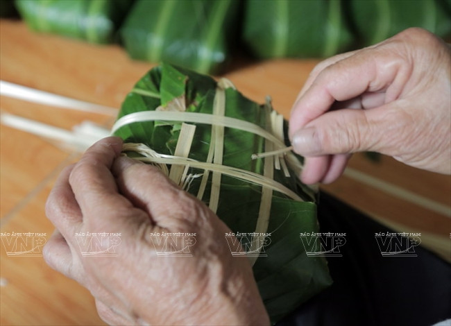 Le bánh chưng est noué avec des ficelles avant d’être cuit dans l’eau bouillante.