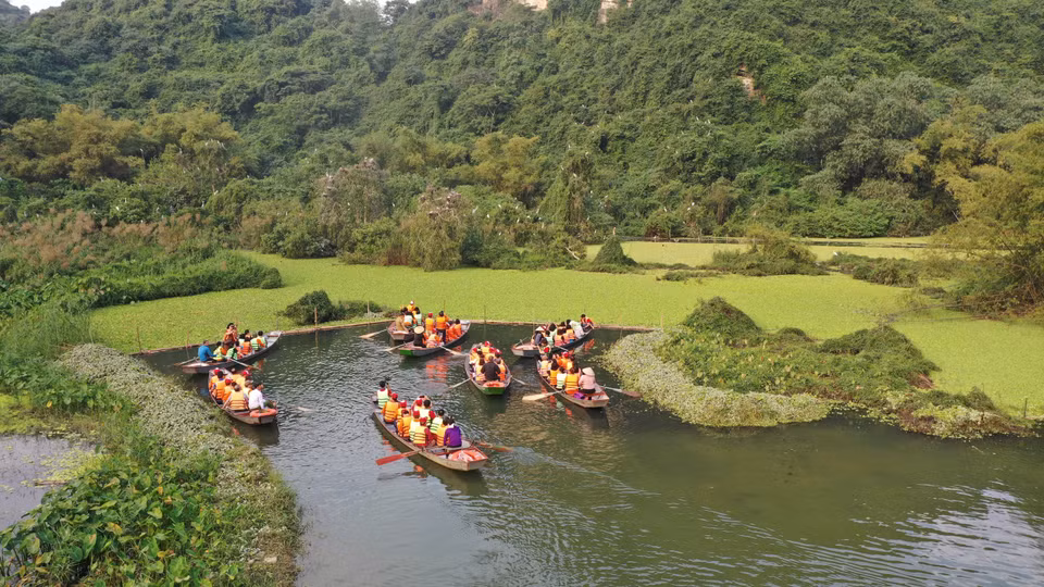 Des visiteurs se rendent dans la vallée du Soleil (Thung Nang). 