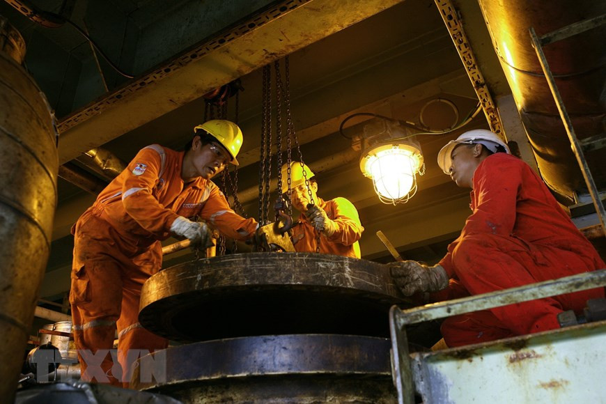 Des ouvriers réparent les équipements dans une plate-forme du gisement de Bach Ho.