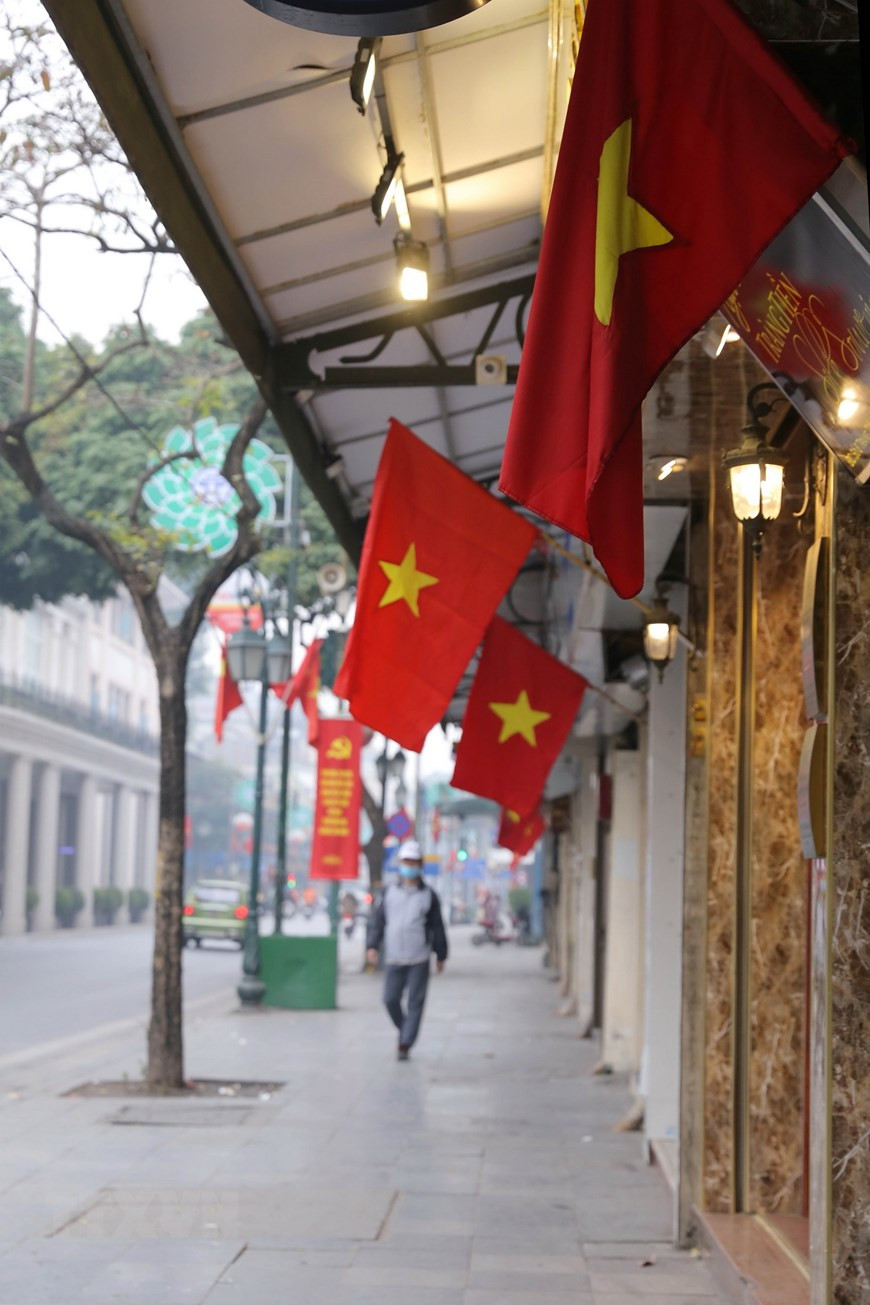 Le drapeau rouge avec étoile jaune le long de la rue Trang Thi pour célébrer le 13e Congrès national du Parti.