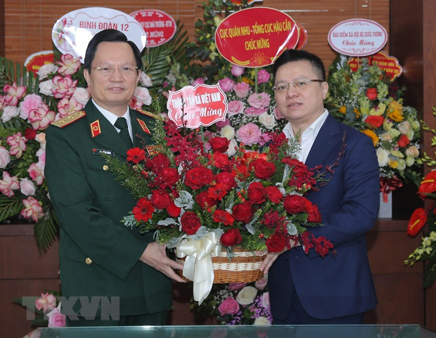Le Quoc Minh, membre du Comité central du Parti, secrétaire du Comité du Parti de la VNA, directeur général adjoint de la VNA, offre un panier de fleurs au professeur et général de division Mai Hong Bang, directeur de l'hôpital militaire 108. Photo: VNA