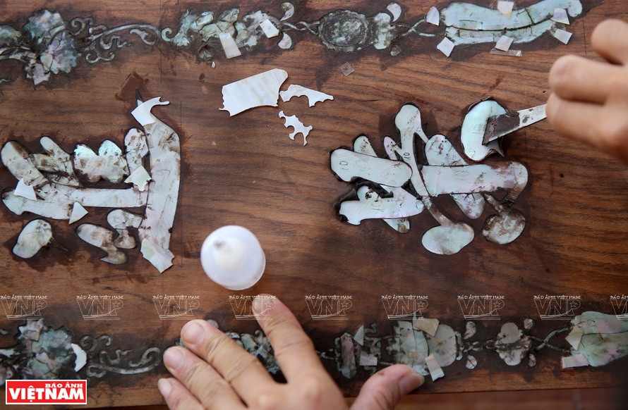 Achèvement d'un produit incrusté de nacre dans le village artisanal du bois de Hai Minh. 