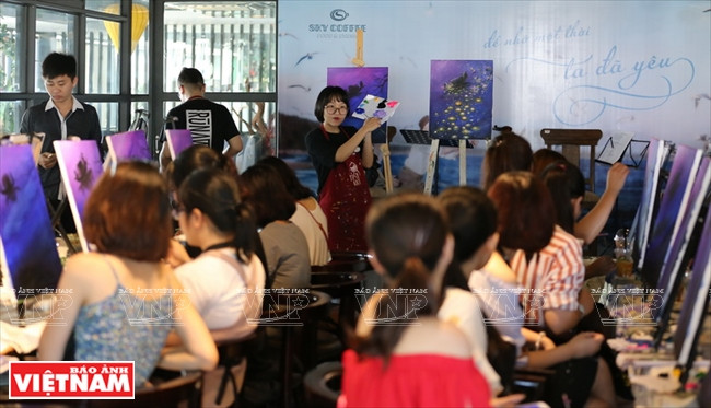 L’enseignante présente une nouvelle technique de peinture.