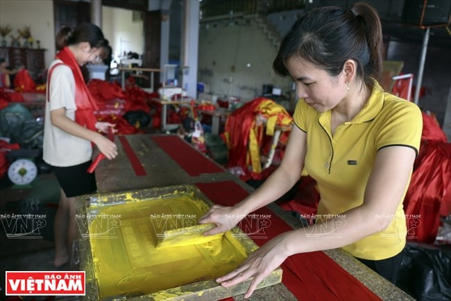 Lors des occasions spéciales, des artisans locaux s'affairent à confectionner des drapeaux nationaux.
