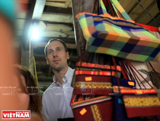 Le touriste américain Brian Bean est intéressé par les produits en brocart des Thai au village de Xiêng