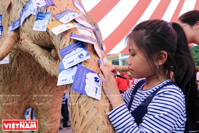 Visiteurs écrivant des messages pour appeler à la protection des animaux sauvages. 