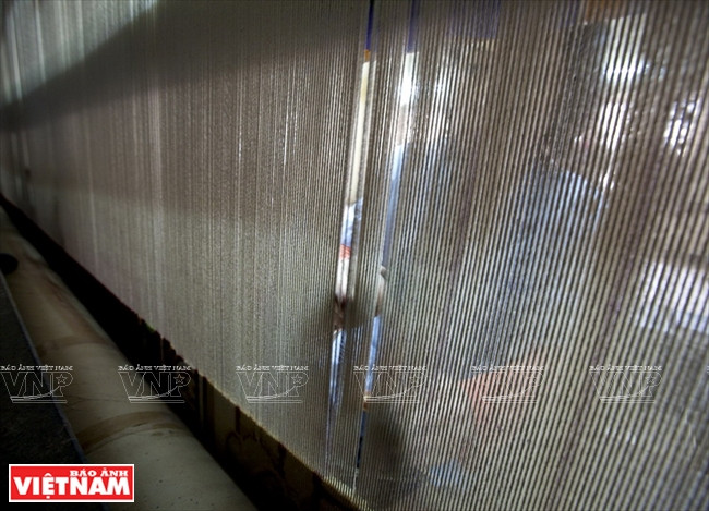 L’artisan noue chaque fil de laine.