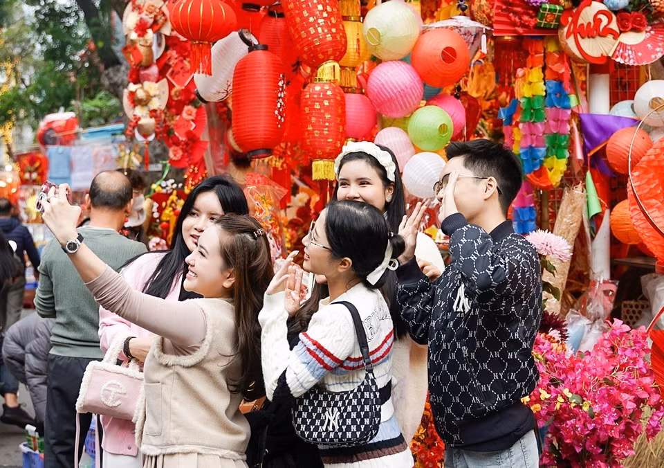  Le marché aux fleurs de Hang Luoc attire toujours de nombreux jeunes qui peuvent prendre de jolies photos souvenirs du printemps naissant. Photo : VNA 