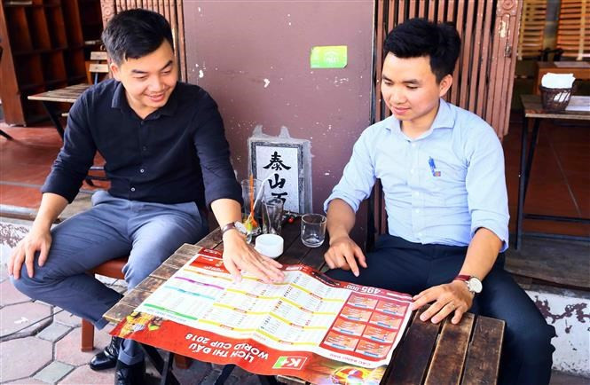 Les jeunes hommes sont ravis de discuter des matchs de la Coupe du monde.