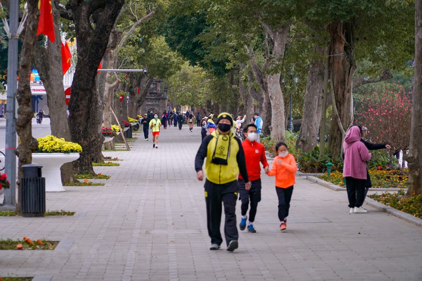Dans un monde en évolution rapide, les Hanoïens peuvent désormais ralentir et profiter d'une vie au rythme lent pendant une semaine de Têt traditionnel. Se promener autour du lac de Hoan Kiêm le premier jour du Nouvel An lunaire est l'habitude de nombreux habitants locaux. Véritable oasis de quiétude au cœur de la trépidante capitale vietnamienne et de son Vieux Quartier typique, le lac de Hoan Kiêm est un lieu de promenade agréable et reposant, aussi apprécié des Hanoïens que des voyageurs. Il y a aussi quelques personnes qui font du vélo autour du lac en profitant de l'air du petit matin. Photo: VietnamPlus