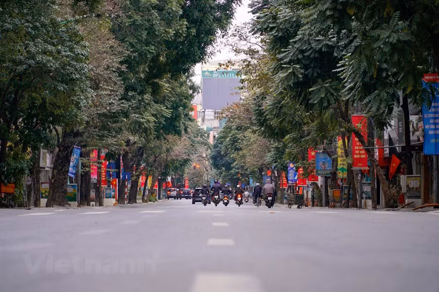 Avant le Nouvel An lunaire, la capitale connaît toujours une ambiance pressée, d’autant plus que le Têt s’approche. Mais le premier matin du Têt traditionnel offre aux habitants de Hanoï un sentiment complètement différent. Au coin d'une rue du Vieux Quartier, il n'y a pas de scènes bruyantes de la vie citadine habituelle, le silence n'est rompu qu'occasionnellement par le bruit de quelques vendeurs. Des drapeaux nationaux sont accrochés à travers la ville, des rues principales aux petites ruelles. L’air est plus pur et l’ambiance est calme. Il fait assez froid le matin du premier jour du premier mois lunaire. Il semble que les gens sortent un peu plus tard par rapport aux années précédentes. Photo: VietnamPlus