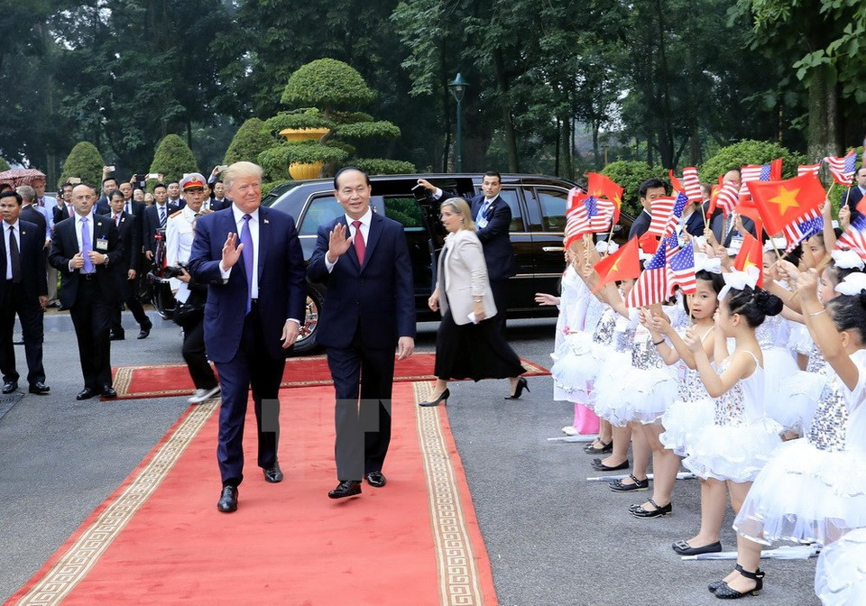 Des enfants de Hanoï saluent les présidents Tran Dai Quang et Donald Trump. 