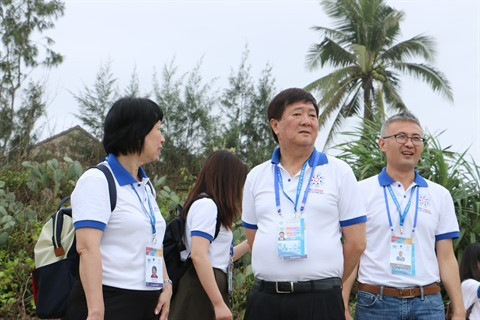 Soh Nga Kok James, président du programme ''Les voix du futur'' (au milieu), chef de la délégation, accompagne les jeunes au bord de la mer Tam Thanh.