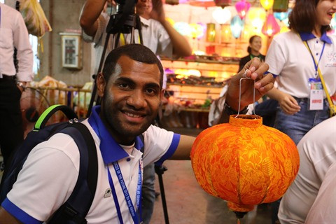 Wiffred Atzier, un jeune représentant de la Papouasie-Nouvelle-Guinée, semble satisfait de son œuvre.