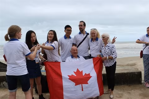 Les jeunes du Forum des Voix du futur prennent des photos de famille au bord de la mer Tam Thanh.