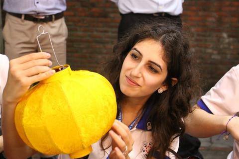 Catalina Villanueva, une jeune représentante du Mexique admire la lanterne qu’elle a fabriquée.